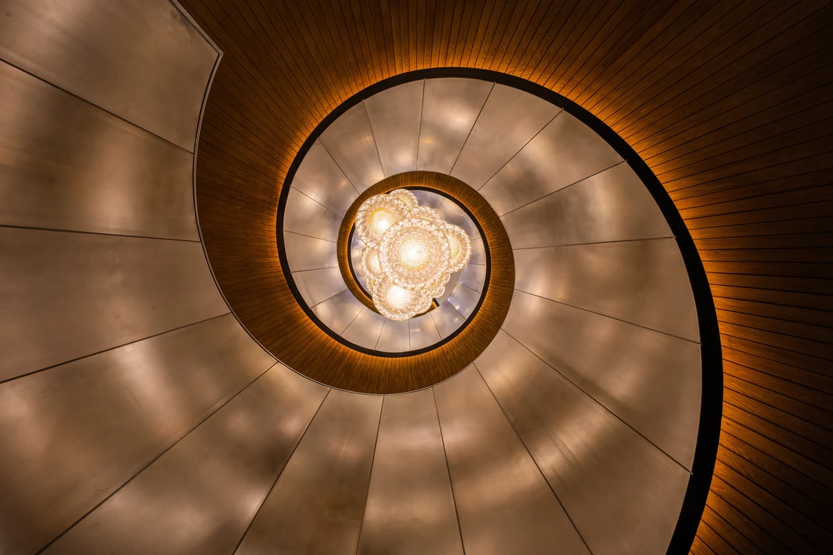 A golden spiral staircase viewed from below