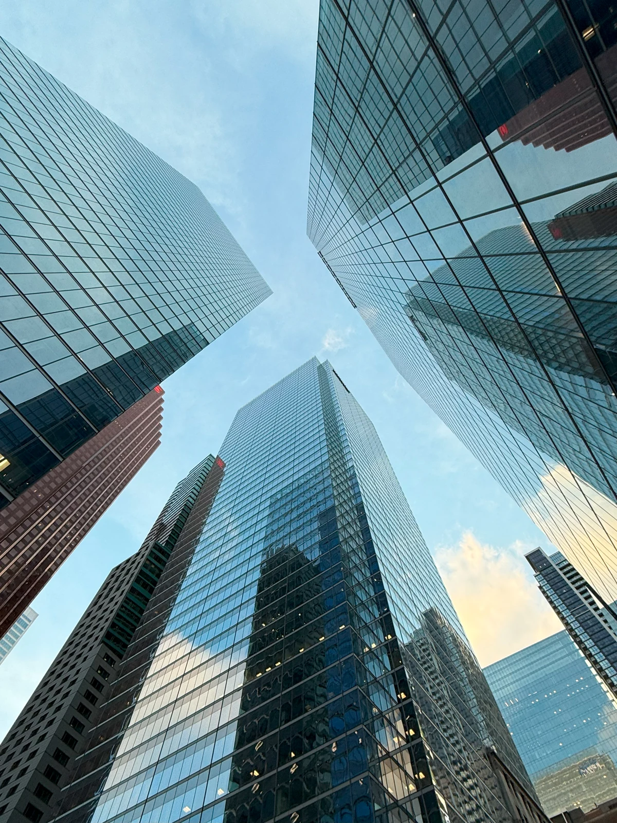 Looking up between modern glass office towers